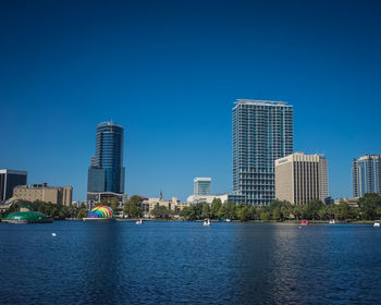 Modern buildings in city against clear blue sky