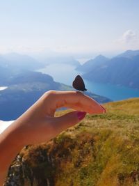 Person holding umbrella against mountain range