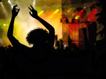 Silhouette person enjoying music concert at night