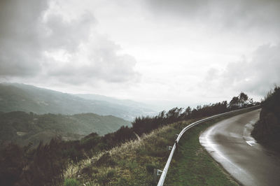 Scenic view of road amidst mountains against sky