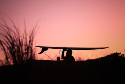 Silhouette man standing against orange sky