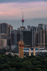 Buildings in city against sky during sunset