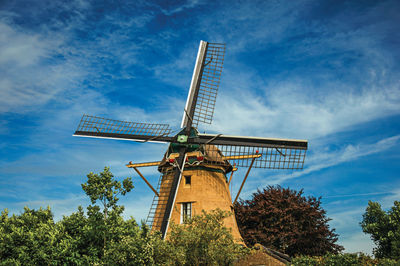 Low angle view of traditional windmill against sky