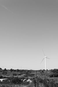 Traditional windmill on field against clear sky