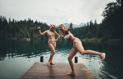 Full length of women on pier over lake against sky