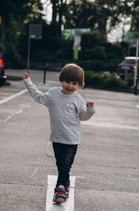 Full length of boy walking on street in city