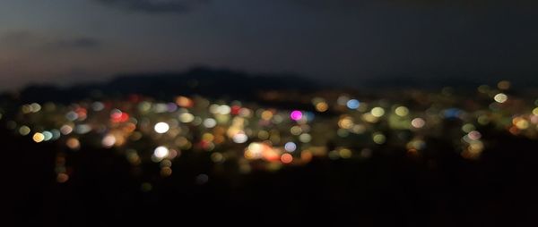 Defocused image of illuminated city at night