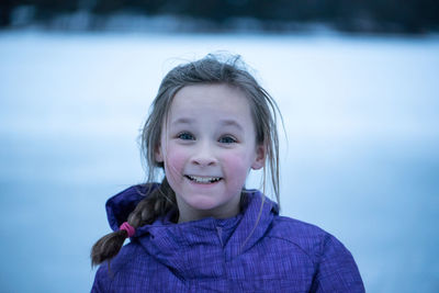 Close-up of happy girl on snow covered field