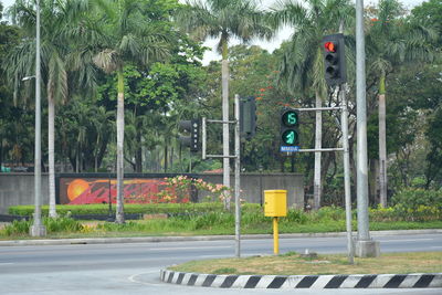 Road sign by trees in city