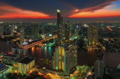 Aerial view of illuminated buildings in city against sky