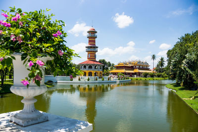 Sculpture by lake and buildings against sky