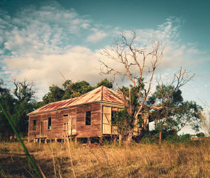 Abandoned house on field against sky