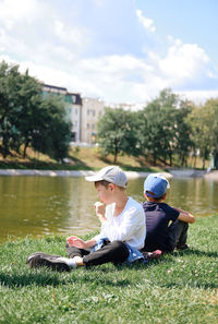 Side view of woman sitting on grassy field