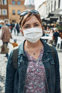 Portrait of woman wearing mask standing on street