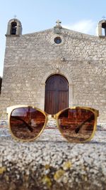 Sunglasses on built structure against sky