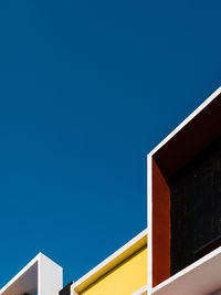 Low angle view of modern building against clear blue sky