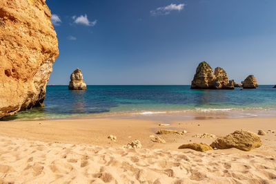 Scenic view of rocks on beach against sky