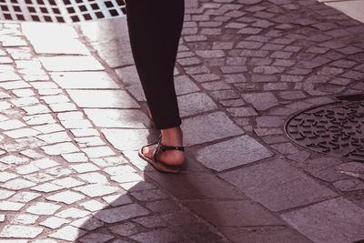 Low section of woman walking on footpath