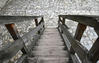 High angle view of empty wooden steps leading towards footpath
