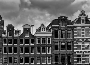 Low angle view of buildings against cloudy sky