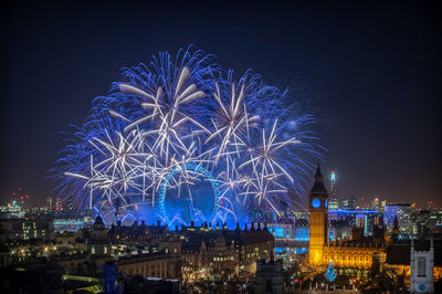 High angle view of firework display at night