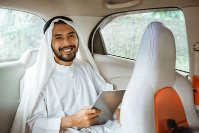 Portrait of female doctor examining patient in car