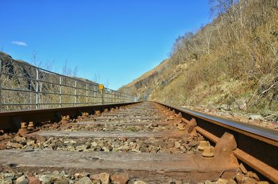 Railroad tracks against clear blue sky