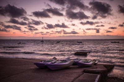 Boats on shore against calm sea