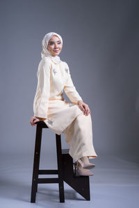 Portrait of smiling young woman sitting on chair