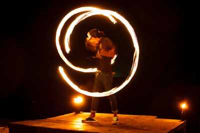 Man standing on illuminated fire at night