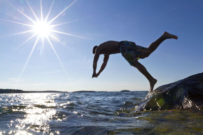 Young man jumping into water