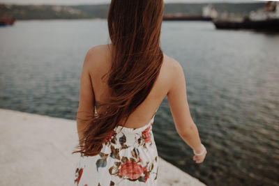 Rear view of woman standing at beach