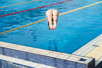Woman jumping in swimming pool