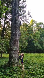 Mother with son standing by tree at park