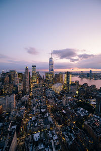 Aerial view of buildings in city at sunset