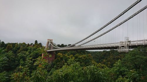 Low angle view of suspension bridge against sky