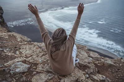 Rear view of woman on rock at beach