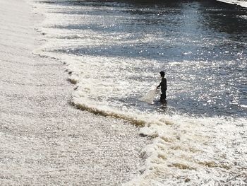 Man surfing on sea shore