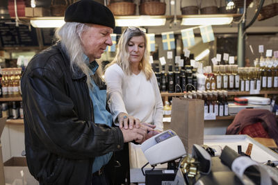 Senior couple using self-checkout at store