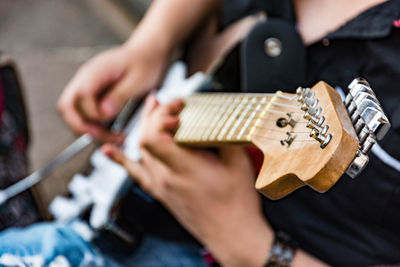 Midsection of man playing guitar