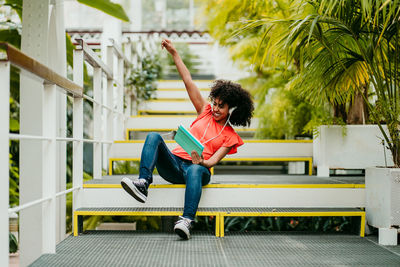 Full length of woman sitting on bench