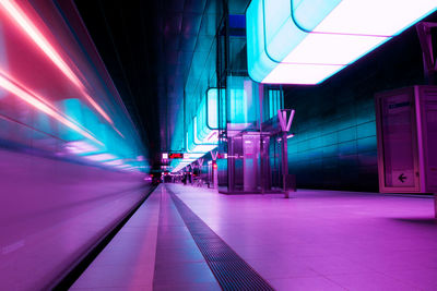 Interior of illuminated railroad station at night