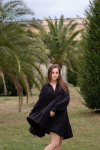 Young woman smiling while standing on field