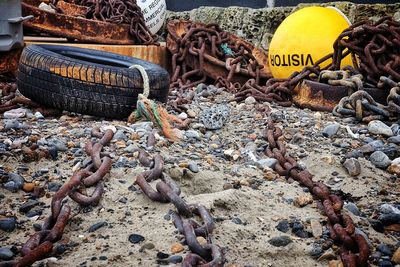 Rusty chains and tires with buoys at beach