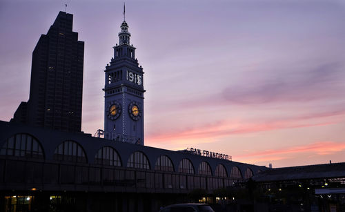 Low angle view of illuminated buildings against sky during sunset