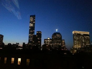 Illuminated cityscape against sky at dusk