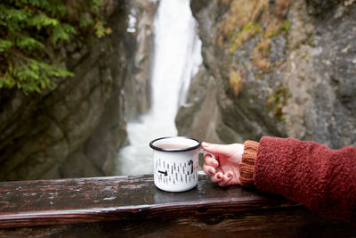 Man holding coffee cup on wood