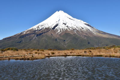 Scenic view of snowcapped mountains against clear blue sky