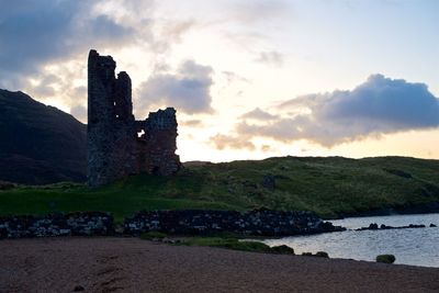 Castle by building against sky during sunset