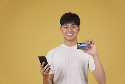 Portrait of smiling man holding mobile phone